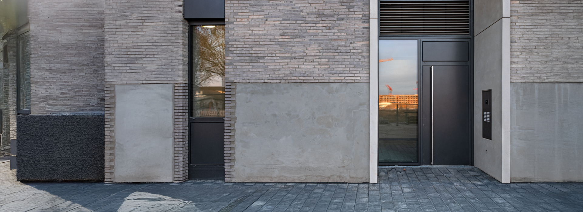 moderne Gebäudefassade mit Eingang und Fenster
E-Öffner 
