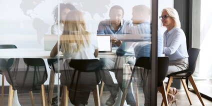 Fünf Personen bei Teammeeting am Tisch