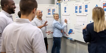 Teammeeting vor Produktionsplänen mit Qualitätskontrolldiagrammen
