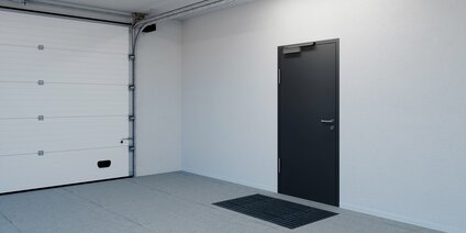 Feuerhemmende Tür mit Mehrfachverriegelung in modernem Garagenraum mit automatischem Sektionaltor
