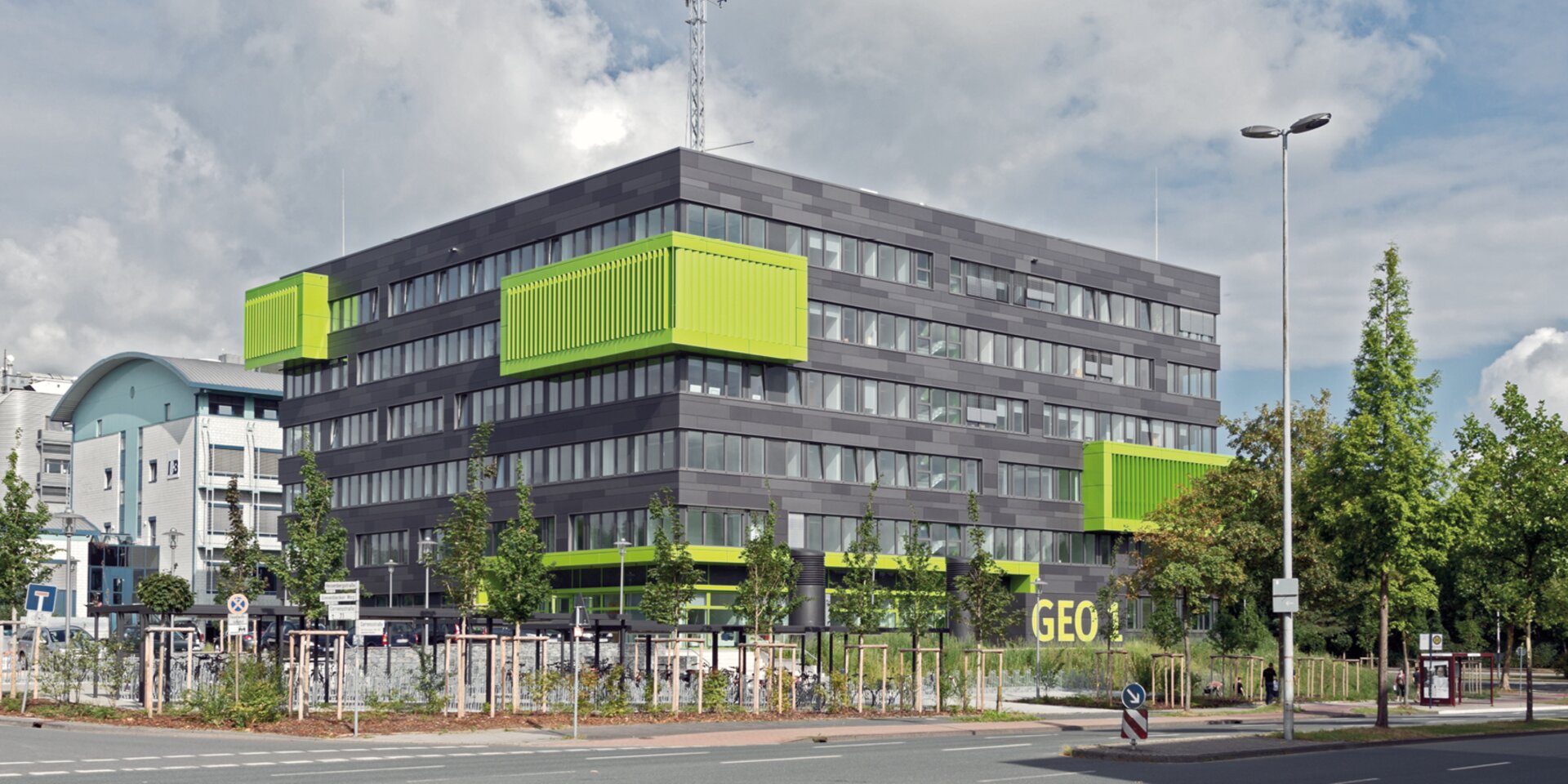 Modernes Gebäude mit grünen Balkonen GEO