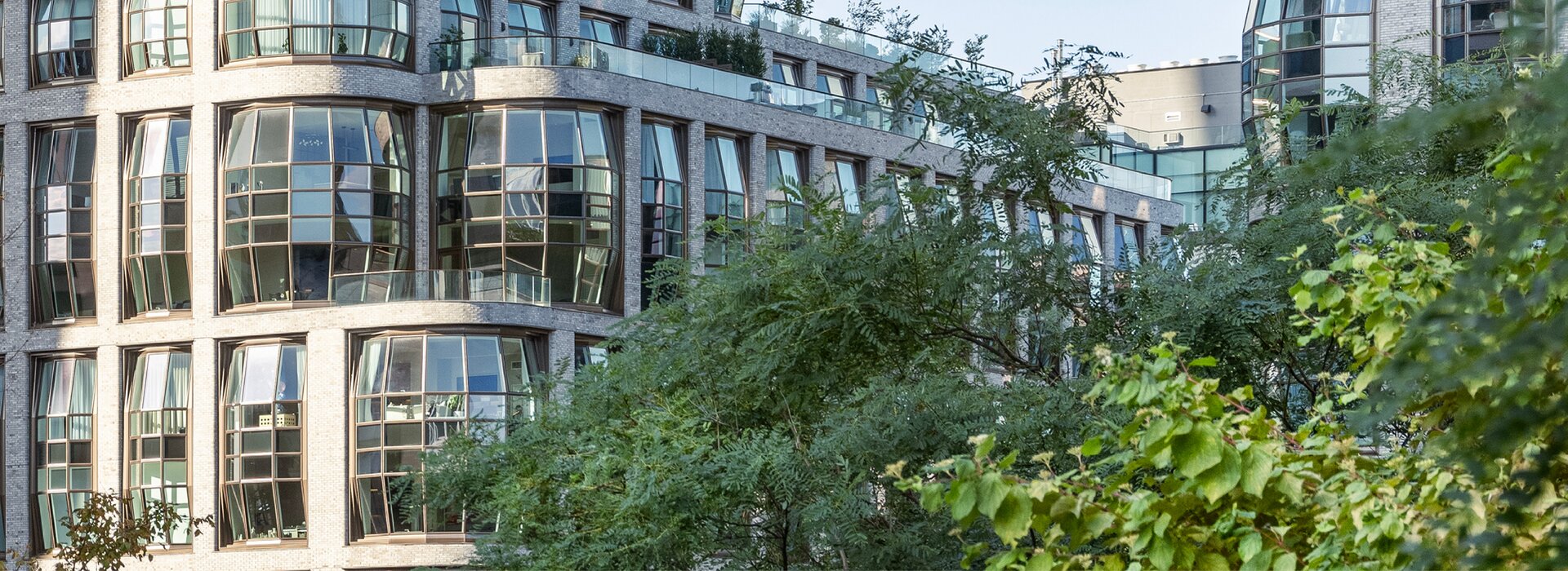 Gebäude mit Glasfassade und grünem Vordergrund