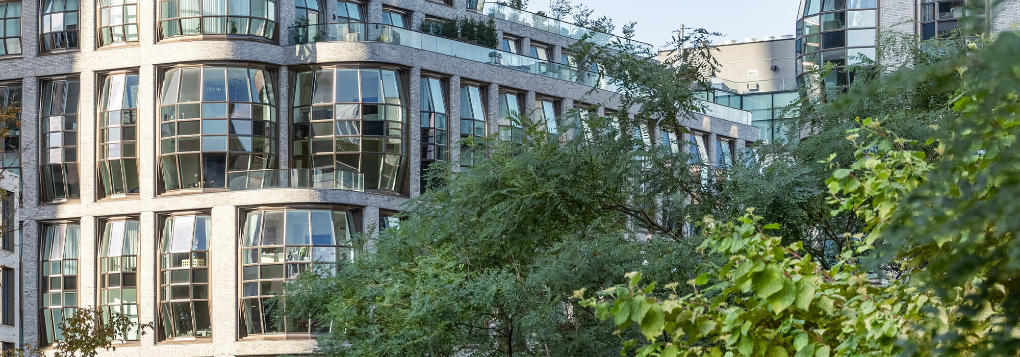 Gebäude mit Glasfassade und grünem Vordergrund