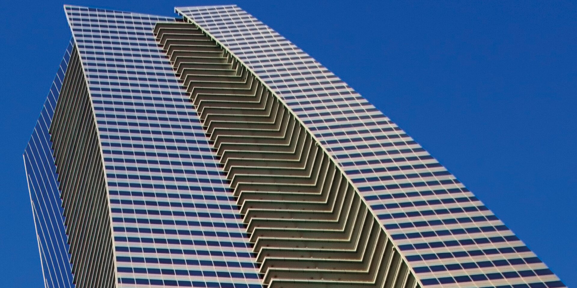 Hochhaus mit Glasfassade und blauem Himmel