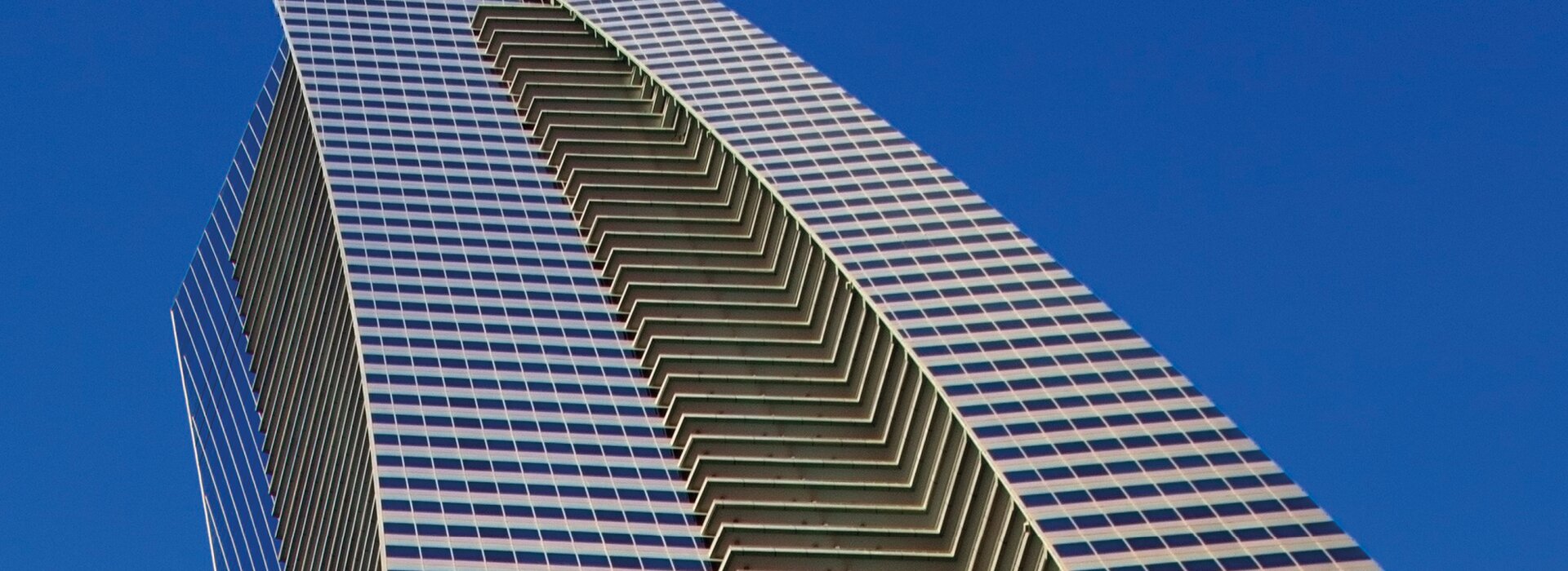 Hochhaus mit Glasfassade und blauem Himmel
