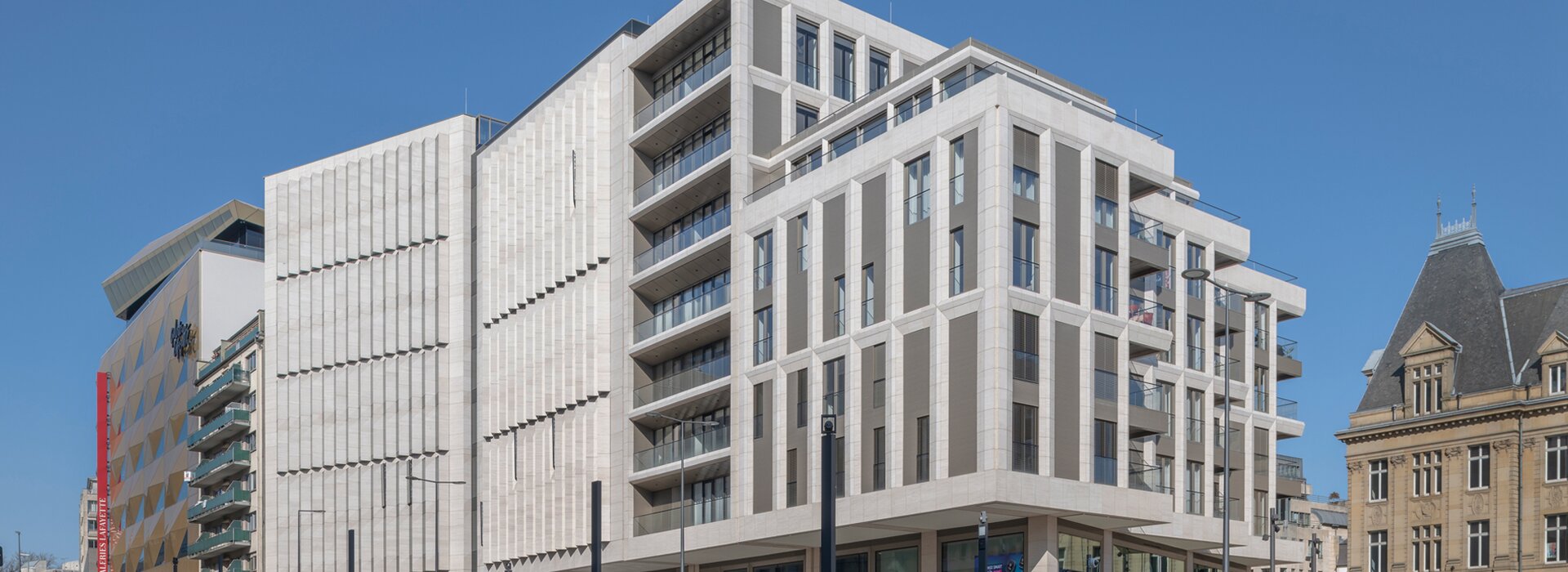 Modernes Gebäude mit Straßenbahn und Menschen