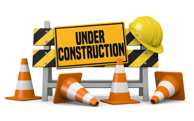 Construction site sign with warning cones and yellow safety helmet on white background